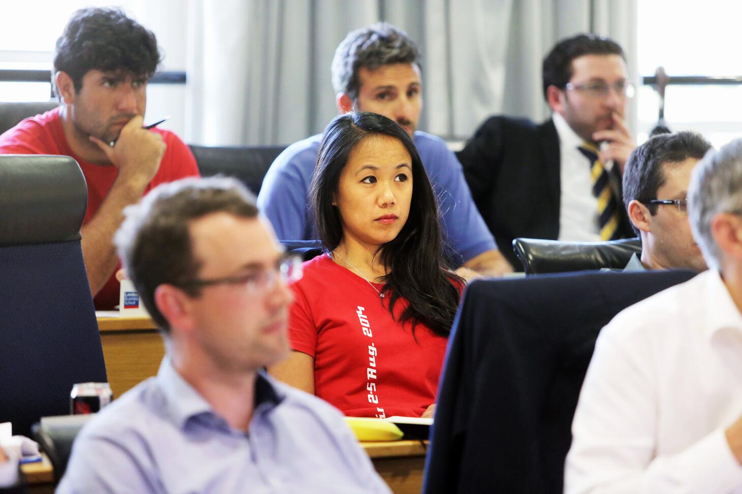 A group of EMBA students listen attentively during a core class lecture